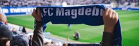 1. FC Magdeburg-Schal wird in die Höhe gehalten