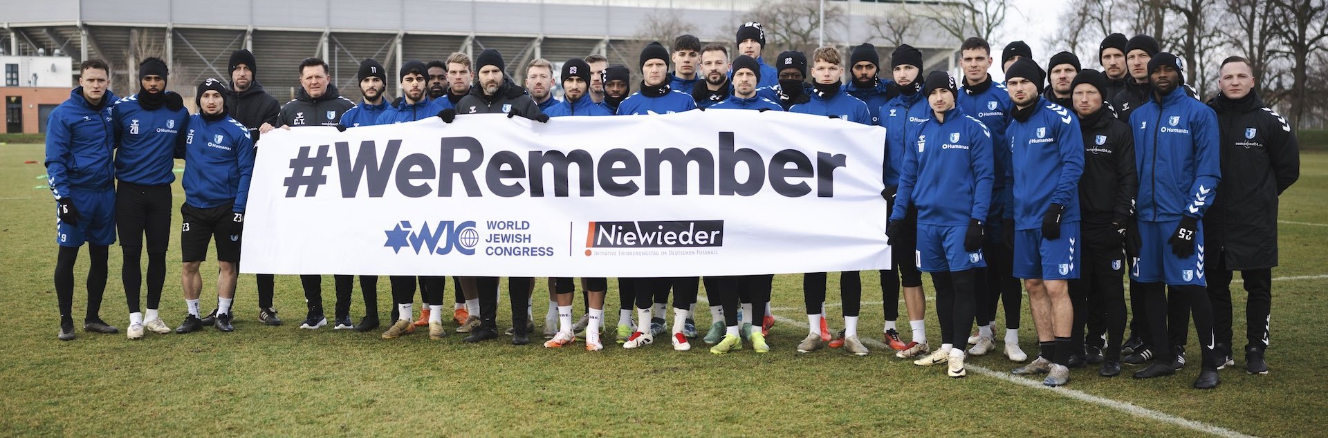 Unsere Mannschaft hält ein Banner mit der Aufschrift #WeRemember