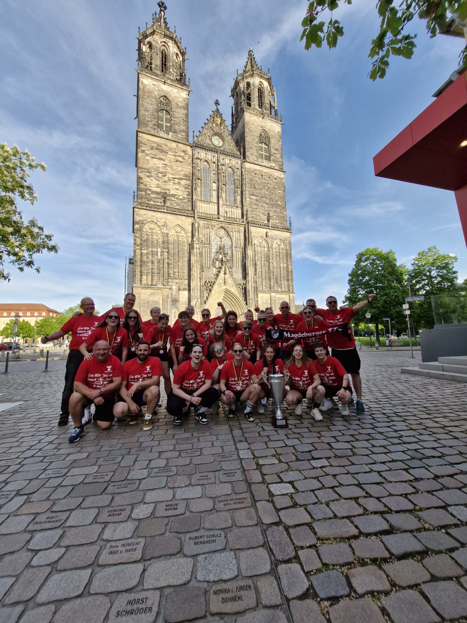 Das Team mit dem Pokal vor dem Magdeburger Dom.